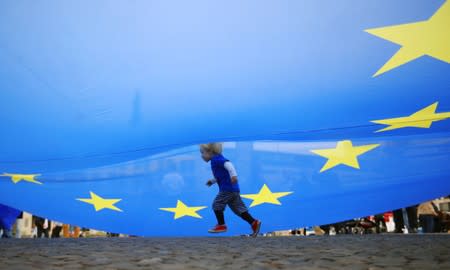 A child runs under an EU flag during a rally under the slogan "Stop the Coup" to protest against attempts to force through a no-deal Brexit, in Berlin