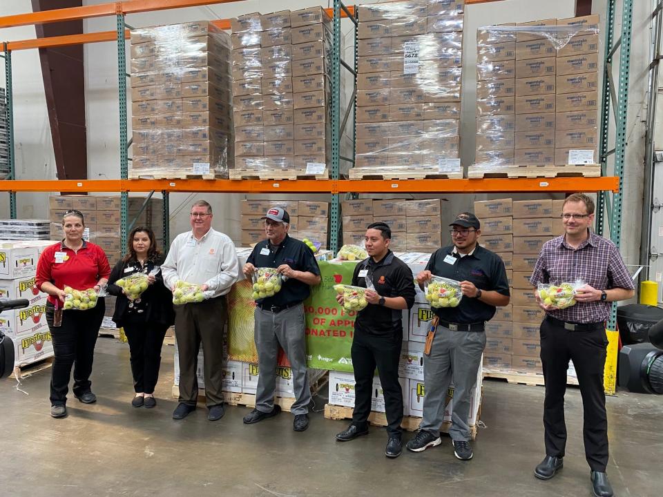 Members of the United Supermarket chain stand with the 4,800 pounds of apples donated Thursday to the High Plains Food Bank of Amarillo.