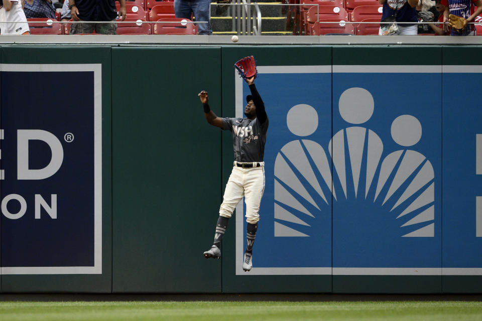 Washington Nationals center fielder Victor Robles leaps up to make a catch on a fly ball by Atlanta Braves' Austin Riley during the fifth inning of a baseball game, Saturday, July 16, 2022, in Washington. (AP Photo/Nick Wass)