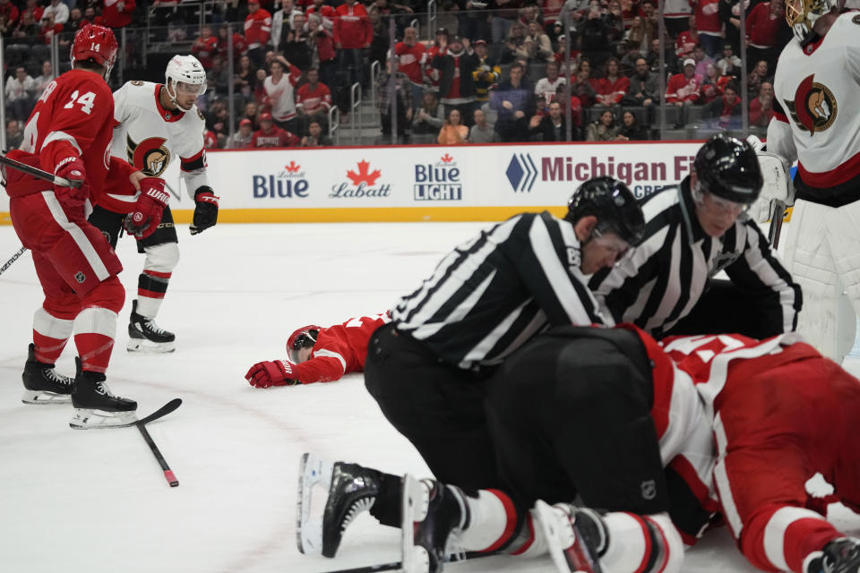 Detroit Red Wings center Dylan Larkin (71) lies on the ice after being hit by Ottawa Senators right wing Mathieu Joseph (21) in the first period of an NHL hockey game Saturday, Dec. 9, 2023, in Detroit. (AP Photo/Paul Sancya)