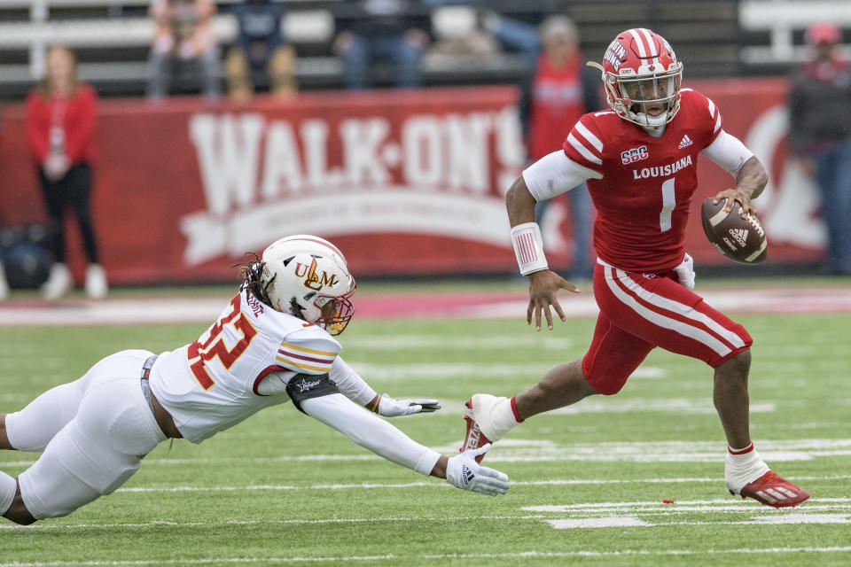 Louisiana-Lafayette quarterback Levi Lewis (1) escapes the grasp of Louisiana-Monroe linebacker Quae Drake (32) in the first half of an NCAA college football game in Lafayette, La., Saturday, Nov. 27, 2021. (AP Photo/Matthew Hinton)