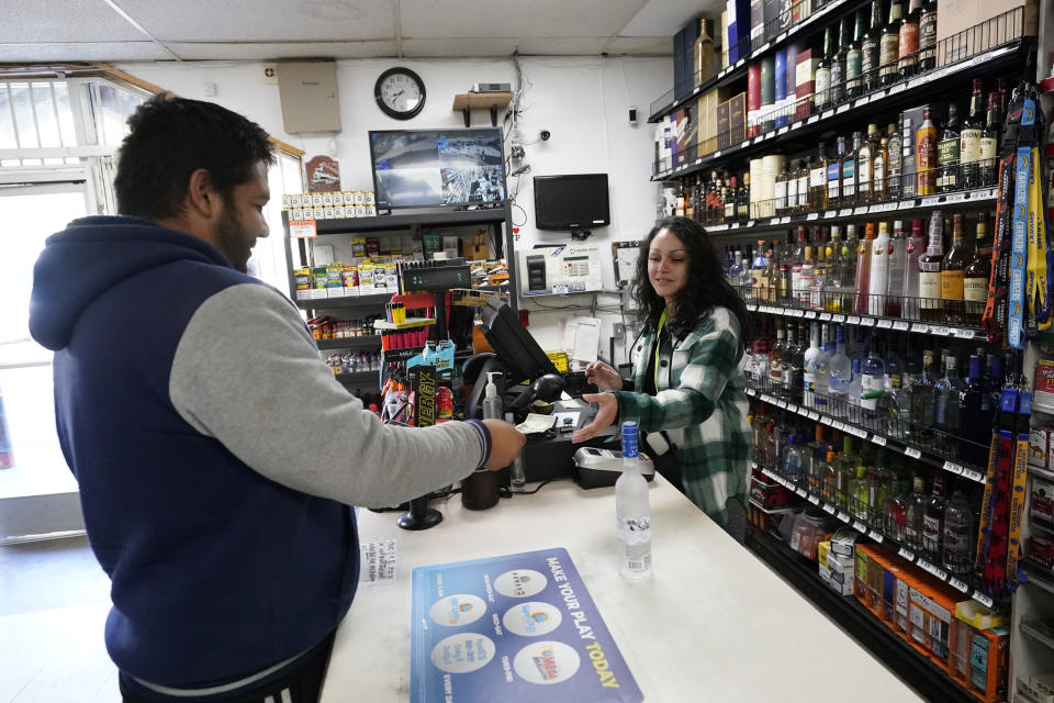 Clerk Janea Herrera, right, helps a customer at the Midway Market & Liquor store where a winning lottery ticket was sold in Frazier Park, Calif., Thursday, Oct. 12, 2023. A player in California won a $1.765 billion Powerball jackpot Wednesday night, ending a long stretch without a winner of the top prize. (AP Photo/Marcio Jose Sanchez)