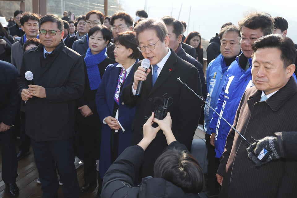 South Korean opposition leader Lee Jae-myung, center, speaks as he visits the construction site of a new airport in Busan, South Korea, Tuesday, Jan. 2, 2024. Lee was attacked and injured by an unidentified man during a visit Tuesday to the southeastern city of Busan, emergency officials said. (Sohn Hyung-joo/Yonhap via AP)