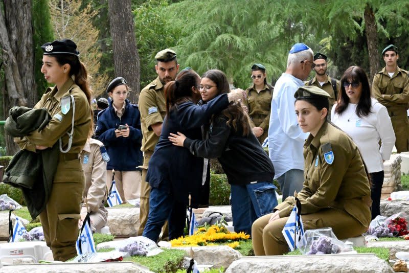 Israelis embrace near the graves of loved ones on Remembrance Day for Israel's fallen soldiers and Victims of Terror. Photo by Debbie Hill/ UPI