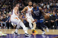 Minnesota Timberwolves guard Mike Conley drives against Phoenix Suns guard Grayson Allen and guard Eric Gordon (23) during the second half of an NBA basketball game Friday, April 5, 2024, in Phoenix. (AP Photo/Rick Scuteri)