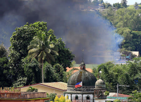 Smoke billowing from a burning building is seen as government troops continue their assault on insurgents from the Maute group, who have taken over large parts of Marawi City, Philippines June 2, 2017. REUTERS/Romeo Ranoco