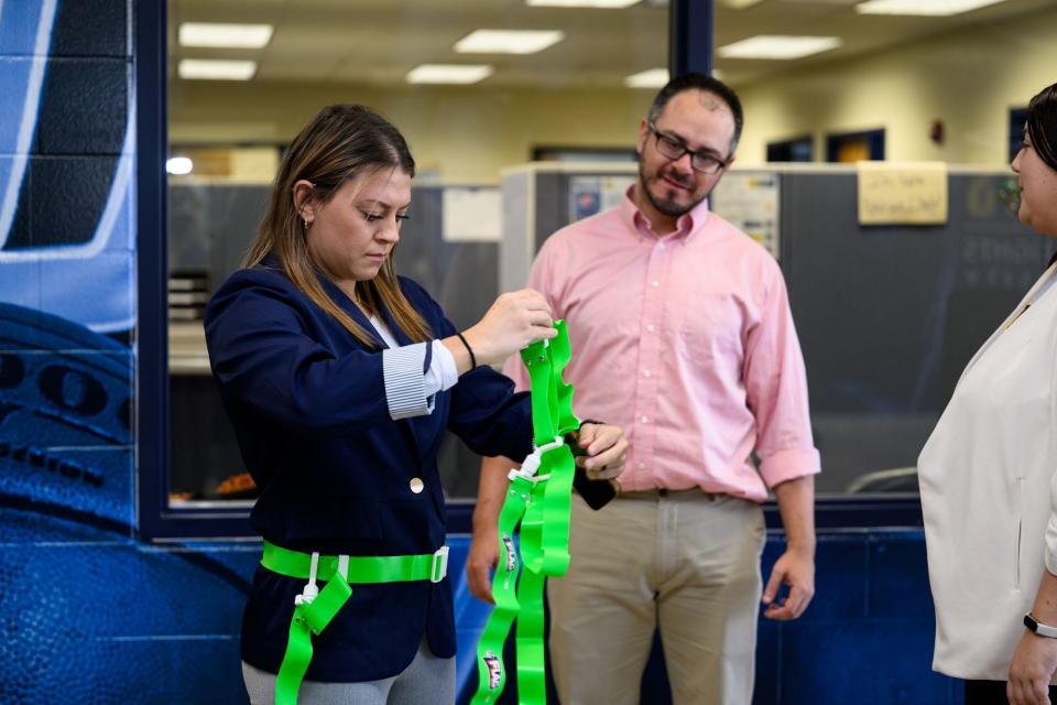 Samantha Bartelotti, senior woman leader and athletics operation manager at Siena Heights University, gets flags ready before a press conference Nov. 1 announcing the college's new women's flag football team with Josh Reilly, the college's sports information director.