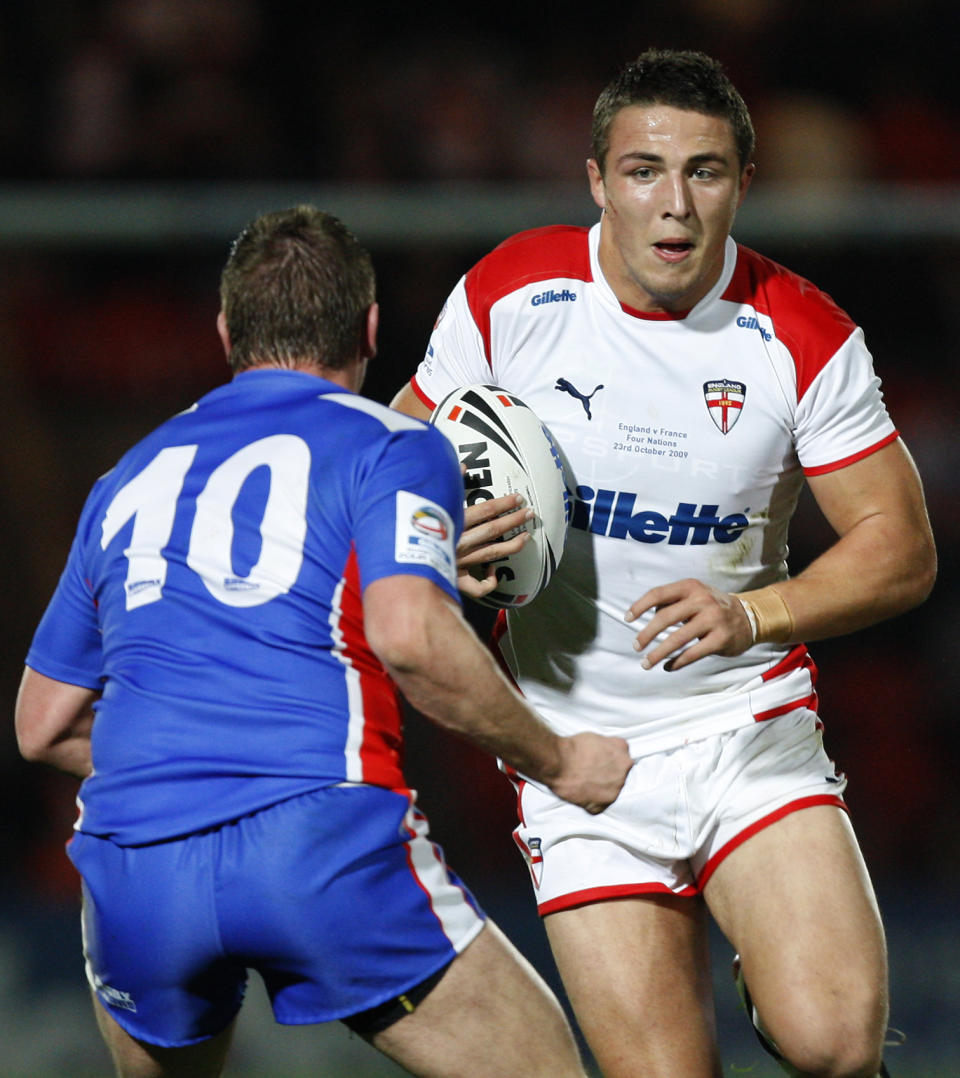 FILE - In this Friday, Oct. 23, 2009 file photo, England's Sam Burgess, right, is tackled by France's Remi Casty, during their Four Nations rugby league match at the Keepmoat Stadium, Doncaster, England. Sam Burgess is switching rugby codes, from league to union, in a bid to become a World Cup winner with England in 2015. The English rugby league forward, who has scored seven tries in 13 international appearances, has signed a three-year deal to join English rugby side Bath and leave the South Sydney Rabbitohs of Australia's National Rugby League after four years. "An opportunity presented itself to head back home to England and to pursue a chance to represent my country in two different sports," Burgess said Monday. Feb. 17, 2014 on the Rabbitohs website. (AP Photo/Jon Super, File)