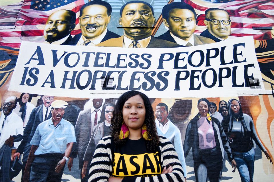 Omari Ho-Sang stands in front of the Ka'Davien Baylor mural that she is depicted in.