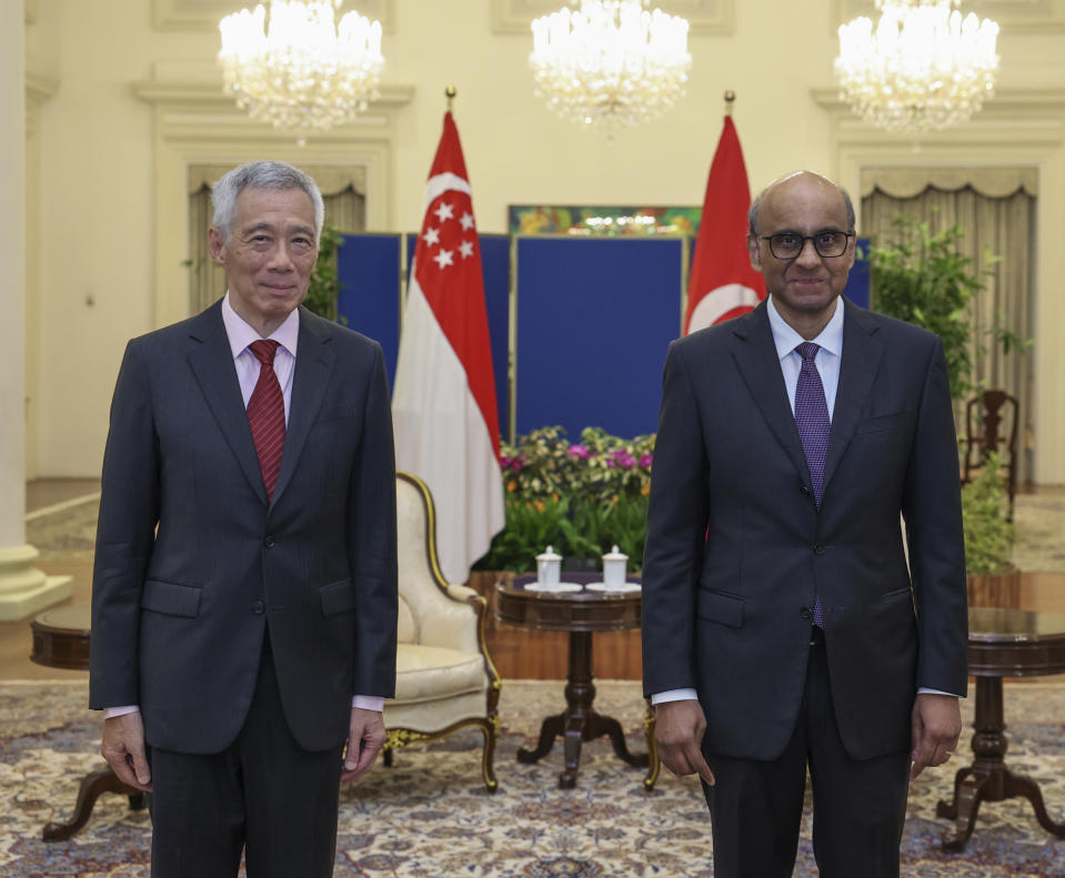 In this photo released by Singapore's Ministry of Communications and Information, Singapore President Tharman Shanmugaratnam, right, poses for a photograph with Singapore's Prime Minister Lee Hsien Loong at the Istana in Singapore, Monday, May 13, 2024. (Mohd Fyrol/Ministry of Communications and Information via AP)