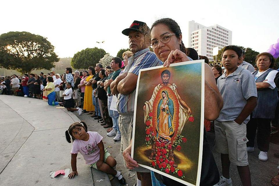 A woman displays a poster of Juan Diego during an outdoor Mass in Los Angeles on July 31, 2002, the day Pope John Paul II canonized him in Mexico. <a href="https://www.gettyimages.com/detail/news-photo/woman-displays-a-poster-of-juan-diego-during-a-mass-at-the-news-photo/51681990?adppopup=true" rel="nofollow noopener" target="_blank" data-ylk="slk:Hector Mata/AFP via Getty Images;elm:context_link;itc:0;sec:content-canvas" class="link ">Hector Mata/AFP via Getty Images</a>