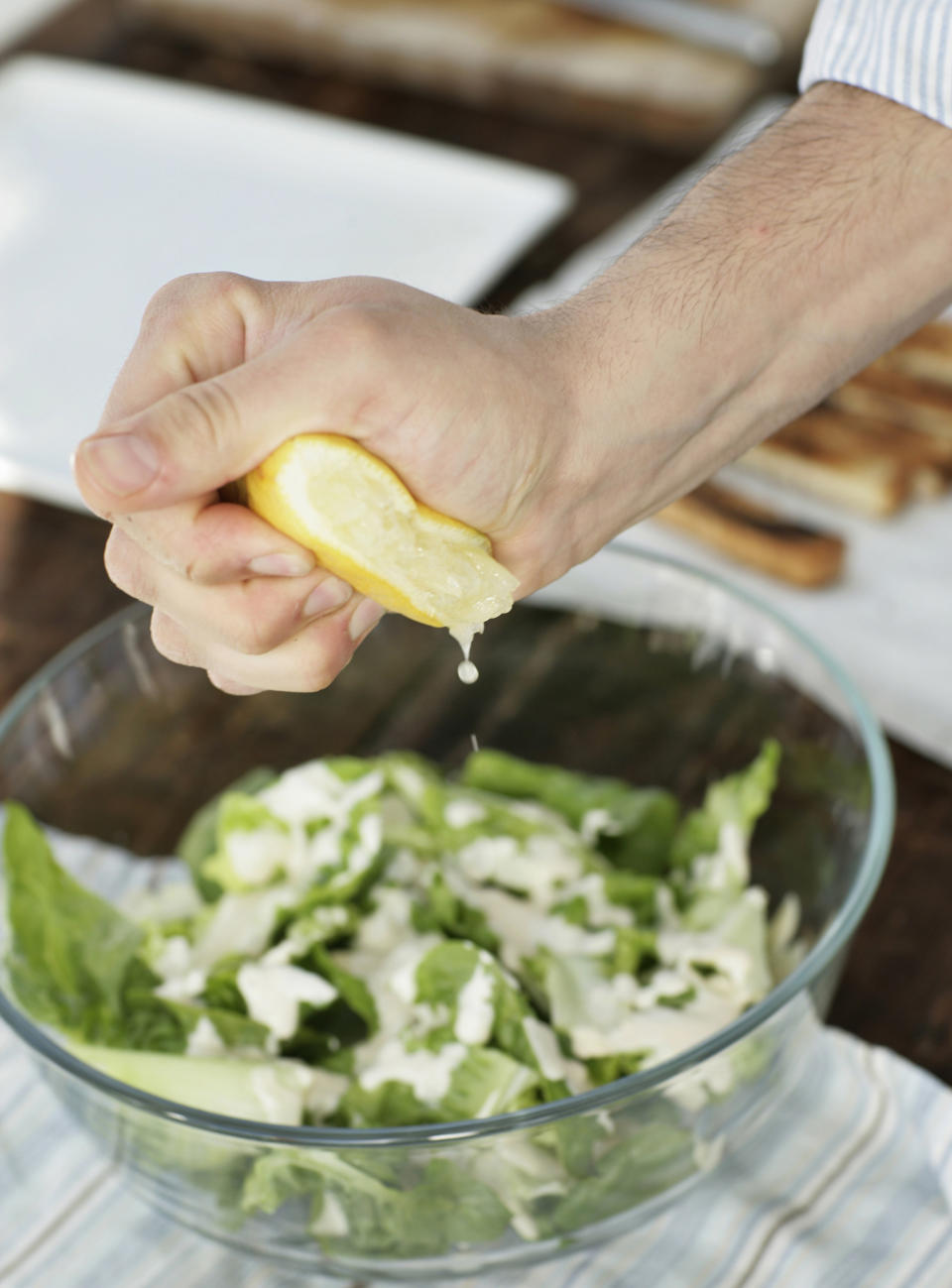 squeezing lemon over salad