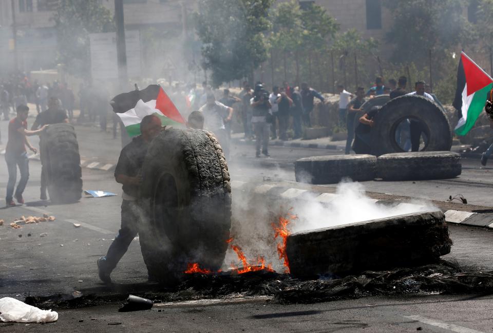 <p>Palestinian protestors burn tires in response to Israeli forces’ intervention during a protest, organized to mark 70th anniversary of Nakba, also known as Day of the Catastrophe in 1948, and against United States’ plans to relocate the U.S. Embassy from Tel Aviv to Jerusalem in Bethlehem, West Bank on May 15, 2018. (Photo: Wisam Hashlamoun/Anadolu Agency/Getty Images) </p>