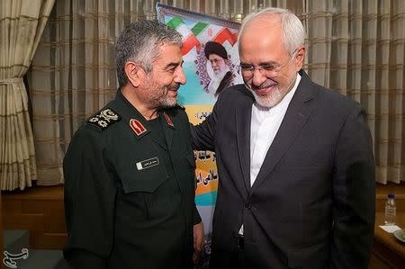 Islamic Revolutionary Guard Corps (IRGC) commander Mohammad Ali Jafari (L) and Iran's Foreign Minister Mohammad Javad Zarif smile during a coordination meeting for the 40th anniversary of the Islamic Revolution, in Tehran, Iran October 9, 2017. Picture taken October 9, 2017. Tasnim News Agency/Handout via REUTERS