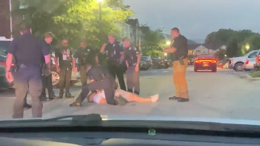 Christopher Hensley receives chest compressions as six other officers who had pinned him down watch on June 15, 2022, in an image captured by a neighbor.