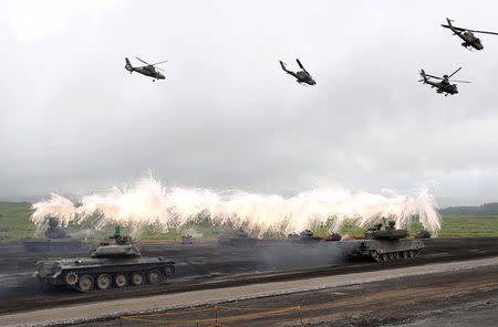 Japanese Ground Self-Defense Force armoured tanks fire during an annual training session near Mount Fuji at Higashifuji training field in Gotemba, west of Tokyo, in this August 19, 2014 file photo. REUTERS/Yuya Shino/Files