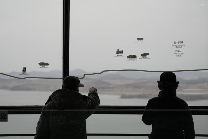 Visitors talk each others as they watch the North Korean side from the unification observatory in Paju, South Korea, Tuesday, March 14, 2023. North Korea test-fired two short-range ballistic missiles in another show of force Tuesday, a day after the United States and South Korea began military drills that Pyongyang views as an invasion rehearsal. (AP Photo/Lee Jin-man)