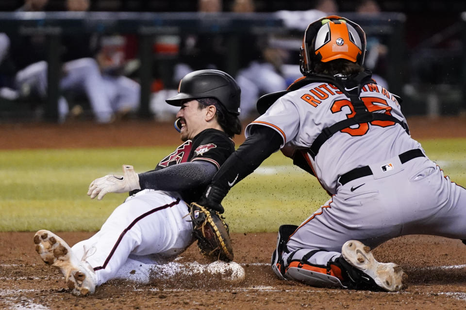 Baltimore Orioles catcher Adley Rutschman, right, tags out Arizona Diamondbacks' Corbin Carroll, left, at home plate during the fourth inning of a baseball game Friday, Sept. 1, 2023, in Phoenix. (AP Photo/Ross D. Franklin)