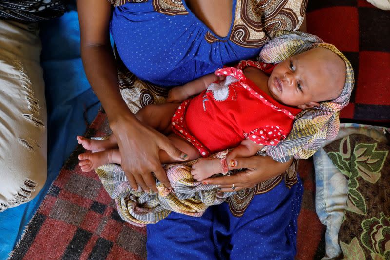 Ethiopian refugee Salam Gberedanos holds her 22 days old daughter Abeyam, at the Village 8 refugees transit camp, which houses Ethiopian refugees fleeing the fighting in the Tigray region, near the Sudan-Ethiopia border