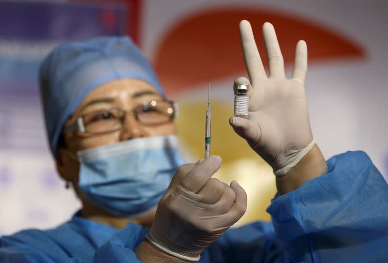 A medical worker shows the QazCovid-in vaccine in Almaty