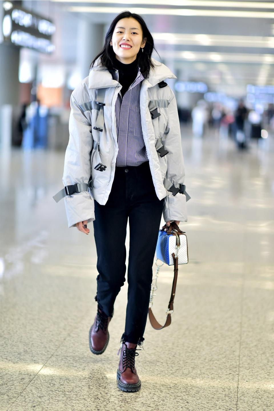 Simple base layers make airport accessories look all the more elevated, like Liu Wen's strappy jacket and box bag over black pants and a turtleneck.