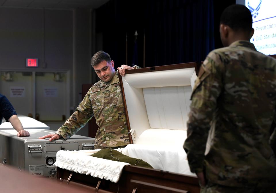 U.S. Air Force Tech. Sgt. Andrew Hampton, 908th Force Support Squadron fitness noncommissioned officer in charge, left, and Staff Sgt. Tra Wilkins, a 908th FSS fitness specialist, reflect while opening a casket during a mortuary affairs training class, April 9, 2024, at Maxwell Air Force Base, Alabama. Members from the services section of the squadron attended various briefings, watched videos and participated in hands-on training provided by the Air Force Mortuary Affairs Operations office.