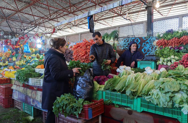 A woman shops at a vegetable and fruit market in Tunis