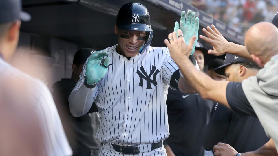 May 8, 2024; Bronx, New York, USA; New York Yankees center fielder Aaron Judge (99) celebrates his solo home run against the Houston Astros with teammates in the dugout during the third inning at Yankee Stadium. 