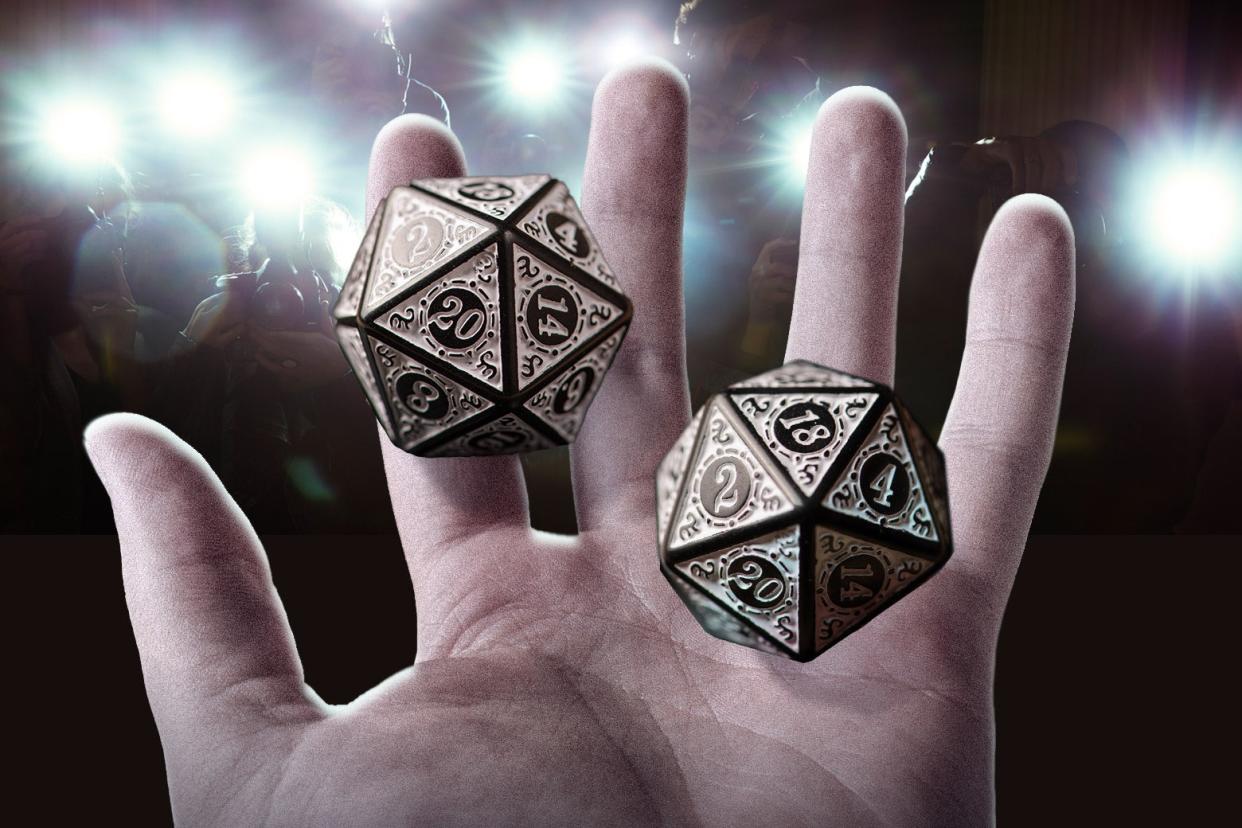 Two 20-sided die hover over a hand.