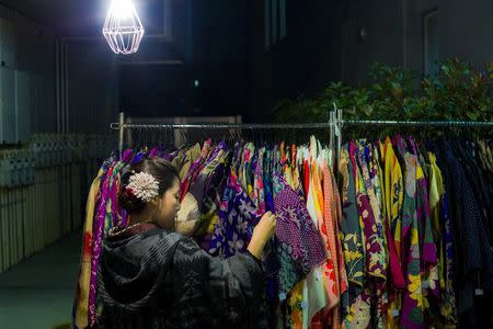 A woman browses through kimonos for sale at Boroichi flea market in Tokyo December 15, 2014. REUTERS/Thomas Peter