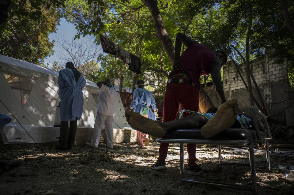 The body of Stanley Joliva who died of cholera symptoms lies on a stretcher while a relative touches him, at a clinic run by Doctors Without Borders in Port-au-Prince, Haiti, Thursday, Oct. 27, 2022. For the first time in three years, people in Haiti have been dying of cholera, raising concerns about a potentially fast-spreading scenario and reviving memories of an epidemic that killed nearly 10,000 people a decade ago. (AP Photo/Ramon Espinosa)