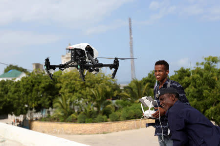 A Somali police officer watches as another flies a DJI Inspire drone during a drone training session for Somali police in Mogadishu, Somalia May 25, 2017. Picture taken May 25, 2017. REUTERS/Feisal Omar