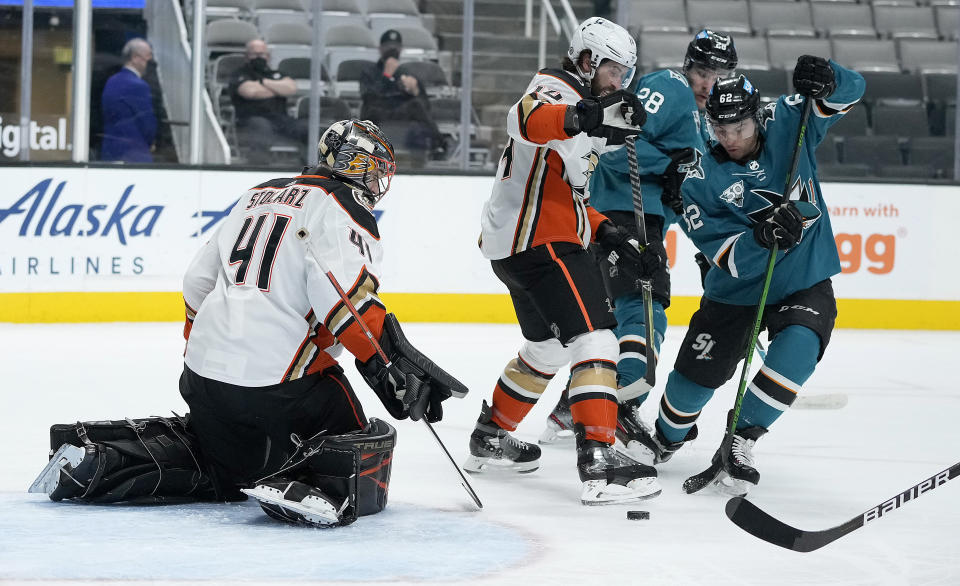 Anaheim Ducks goaltender Anthony Stolarz (41) blocks a shot by San Jose Sharks right wing Kevin Labanc (62) as center Adam Henrique (14) defends during the first period of an NHL hockey game Wednesday, April 14, 2021, in San Jose, Calif. (AP Photo/Tony Avelar)