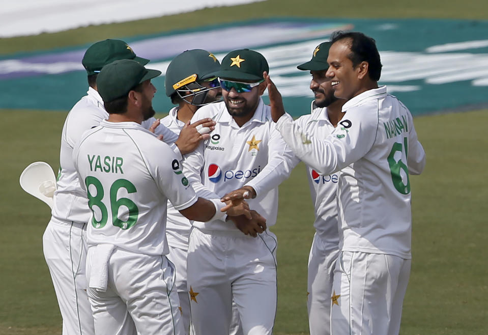 Pakistan's Nauman Ali, right, celebrates with teammates after taking the wicket of South Africa's batsman Dean Elgar during the first day of the first cricket test match between Pakistan and South Africa at the National Stadium, in Karachi, Pakistan, Tuesday, Jan. 26, 2021. (AP Photo/Anjum Naveed)