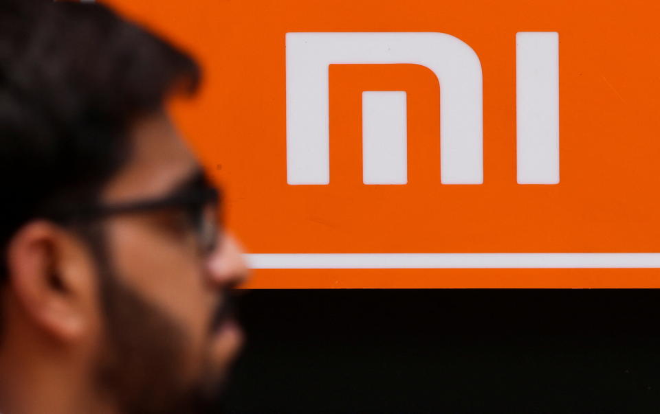 A man walks past a logo of Xiaomi, a Chinese manufacturer of consumer electronics, outside a shop in Mumbai, India, May 11, 2022. REUTERS/Francis Mascarenhas