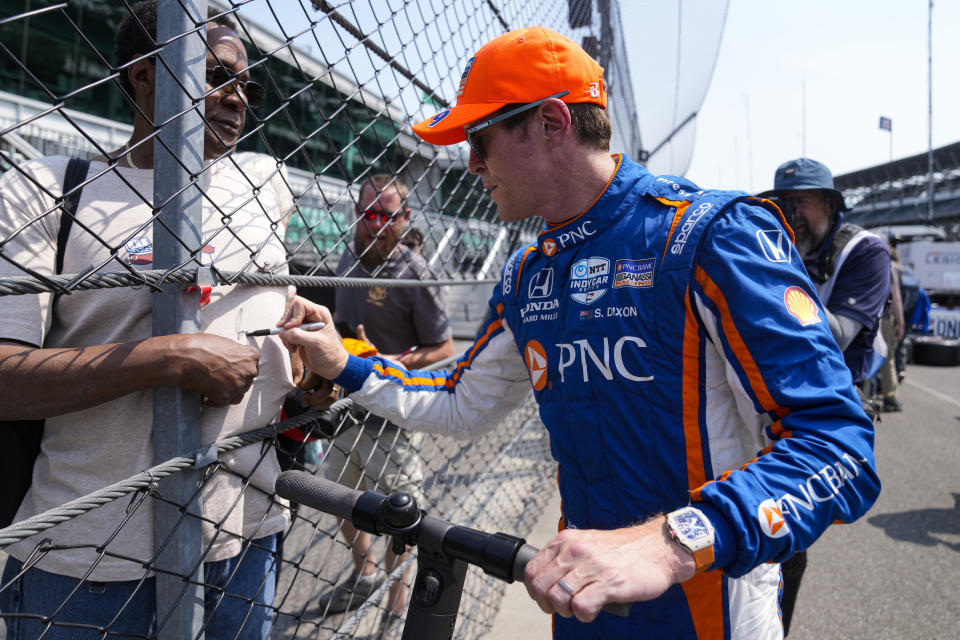 Scott Dixon, of New Zealand, signs a shirt for a fan as he leaves the pit area during practice for the Indianapolis 500 auto race at Indianapolis Motor Speedway in Indianapolis, Wednesday, May 17, 2023. (AP Photo/Michael Conroy)