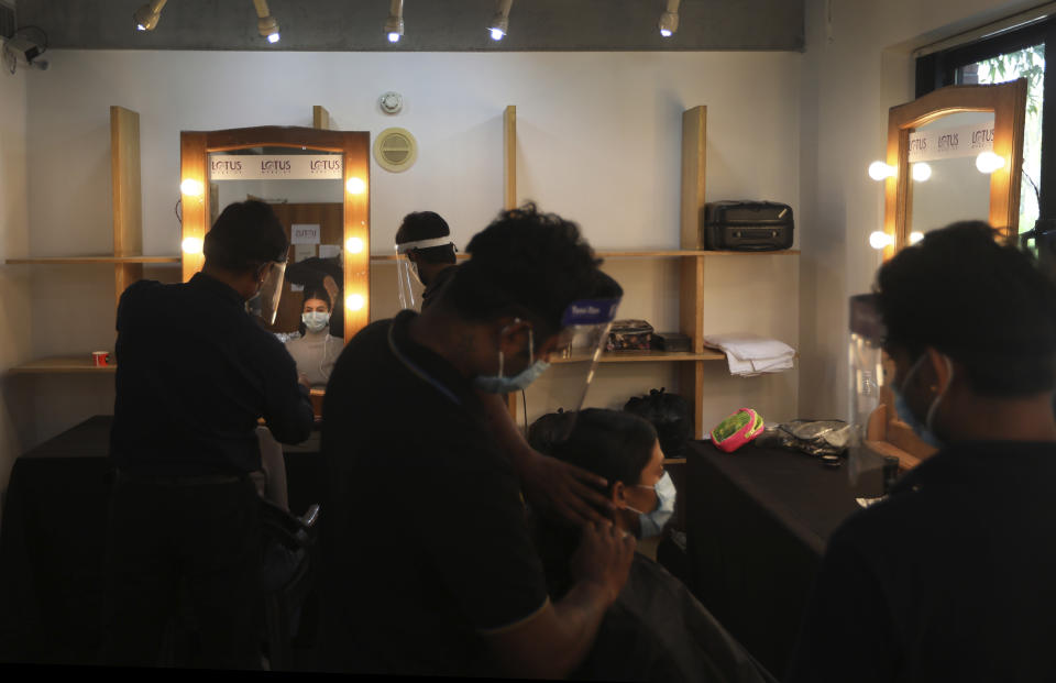 Models get their hair done for a shoot for the Lotus make-up India Fashion week digital show at the Fashion Design Council of India (FDCI) office in New Delhi, India, Friday, Oct. 2, 2020. India’s first digital fashion week is being held from Oct. 14-18, live streaming the spring-summer collections by more than 40 fashion designers under the banner of Lotus Make-up India Fashion Week. Not to miss the October deadline, the FDCI converted parts of its office building into a studio in a bustling industrial area of Delhi. It created a stage, screens and bespoke lighting to facilitate shooting of fashion films and videos by the designers. (AP Photo/Manish Swarup)