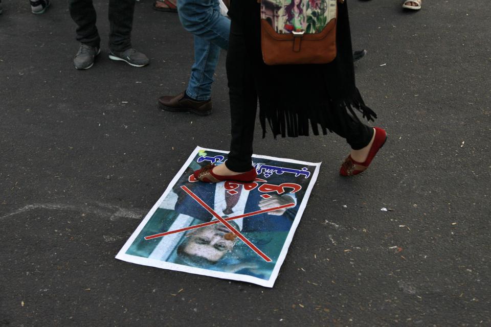 A poster with a defaced picture of Asaad al-Eidani, Iran-backed parliamentary bloc's nominee for the post of the prime minister and Arabic that reads "rejected by the people," lying on the ground in Tahrir Square during anti-government demonstrations in Baghdad, Iraq, Thursday, Dec. 26, 2019. Iraq's president refused Thursday to designate the Iran-backed parliamentary bloc's nominee for prime minister after he was rejected by anti-government protesters, saying he was prepared to submit his resignation to Parliament. Barham Saleh said in a statement issued by his office that he would not name the governor of the southern Basra province, Asaad al-Eidani, as the country's next prime minister "to avoid more bloodshed and in order to safeguard civil peace." (AP Photo/Khalid Mohammed)