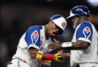 Atlanta Braves' Ronald Acuna Jr., left, is congratulated by first base coach Eric Young Sr. after Acuna's home run during the seventh inning of a baseball game against the Miami Marlins on Wednesday, April 14, 2021, in Atlanta. (AP Photo/Brynn Anderson)