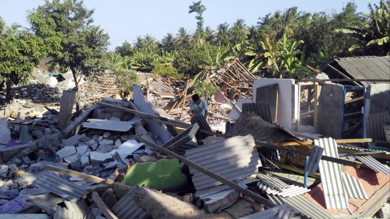 Ein Mann durchsucht die Trümmer zerstörter Häuser nach dem jüngsten Erdbeben auf der Insel Lombok. Foto: Fauzy Chaniago/AP
