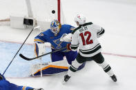 Minnesota Wild's Matt Boldy (12) is unable to score past St. Louis Blues goaltender Jordan Binnington during overtime of an NHL hockey game Saturday, March 16, 2024, in St. Louis. (AP Photo/Jeff Roberson)