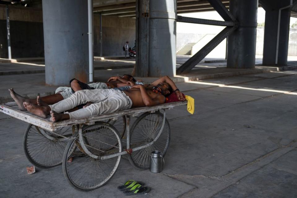 Men rest on a cart under a bridge near Sabarmati river during a hot day in Ahmedabad, India, on May 28, 2019.<span class="copyright">Sam Panthaky—Getty Images</span>