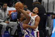 Sacramento Kings forward Harrison Barnes, left, is fouled by Portland Trail Blazers guard CJ McCollum, right, during the first quarter of an NBA basketball game in Sacramento, Calif., Wednesday, Jan. 13, 2021. (AP Photo/Rich Pedroncelli)