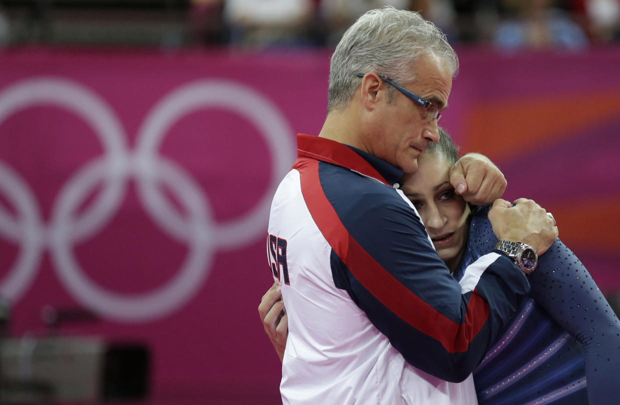 FILE - In this Aug. 7, 2012, file photo, U.S. gymnast Jordyn Wieber is consoled by head coach John Geddert after her performance during the artistic gymnastics women's floor exercise final at the 2012 Summer Olympics in London. The finality of the end of her gymnastics career hit Wieber suddenly. Too far removed from the high-intensity training needed to continue at the elite level and ineligible to compete collegiately because she turned professional as a high schooler, the 2011 world champion and 2012 Olympic gold medalist needed a place to vent. 
 (AP Photo/Gregory Bull, File)