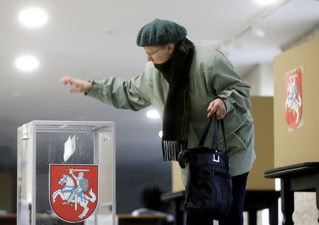 A woman casts her vote during a general election run-off in Birzai, Lithuania, October 23, 2016. REUTERS/Ints Kalnins