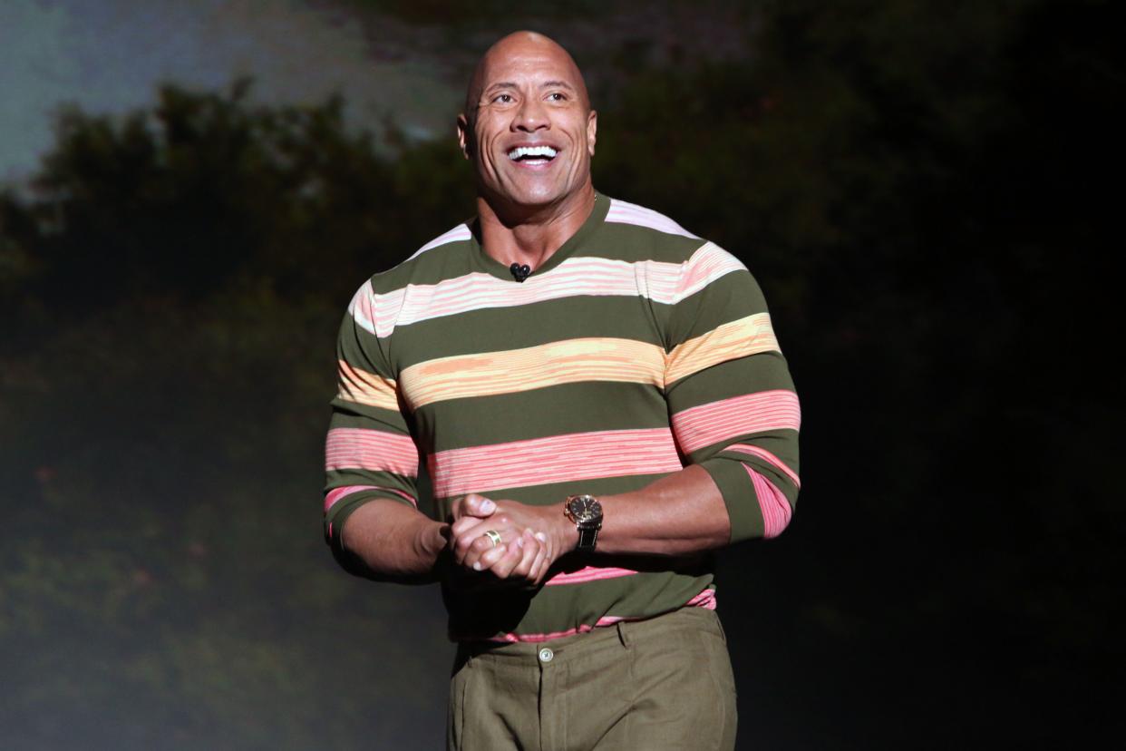 Dwayne Johnson smiling and presenting on stage