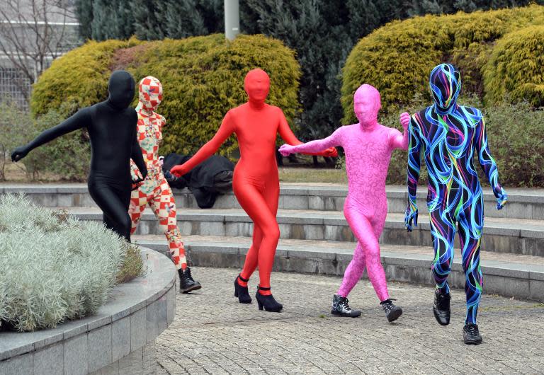 Members of the Tokyo Zentai Club, part of a subset in Japan with a fetish for wearing outfits called "zentai" -- an abbreviation of "zenshintaitsu", which means "full body suit" walk through a park in Tokyo, January 25, 2014