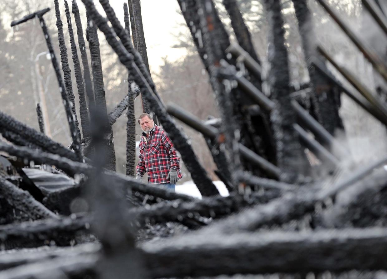 Granite State Fair board member Tom Dubois looks at what is left of a barn which once held horses at the fairgrounds in Rochester March 1, 2022 following a fire Monday night.