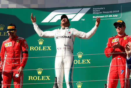 FILE PHOTO: Mercedes’ Lewis Hamilton celebrates winning Hungarian Grand Prix alongside second placed Ferrari’s Sebastian Vettel and third placed Ferrari’s Kimi Raikkonen at Hungaroring, Budapest, Hungary - July 29, 2018. REUTERS/Bernadett Szabo/File Photo