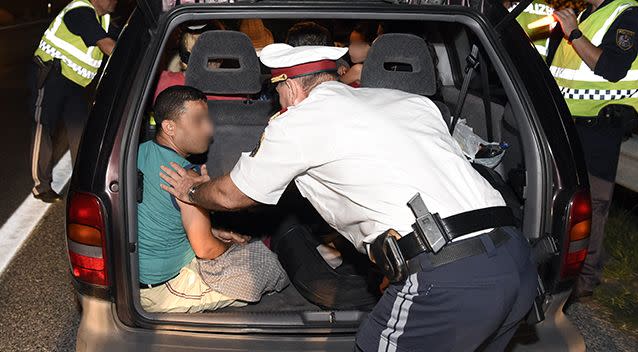 Austrian Police officers stop and search a car with nine adults and two children (a Persan man hid in the trunk) as they patrol on the motorway near the Austro-Hungarian border. Source: AAP